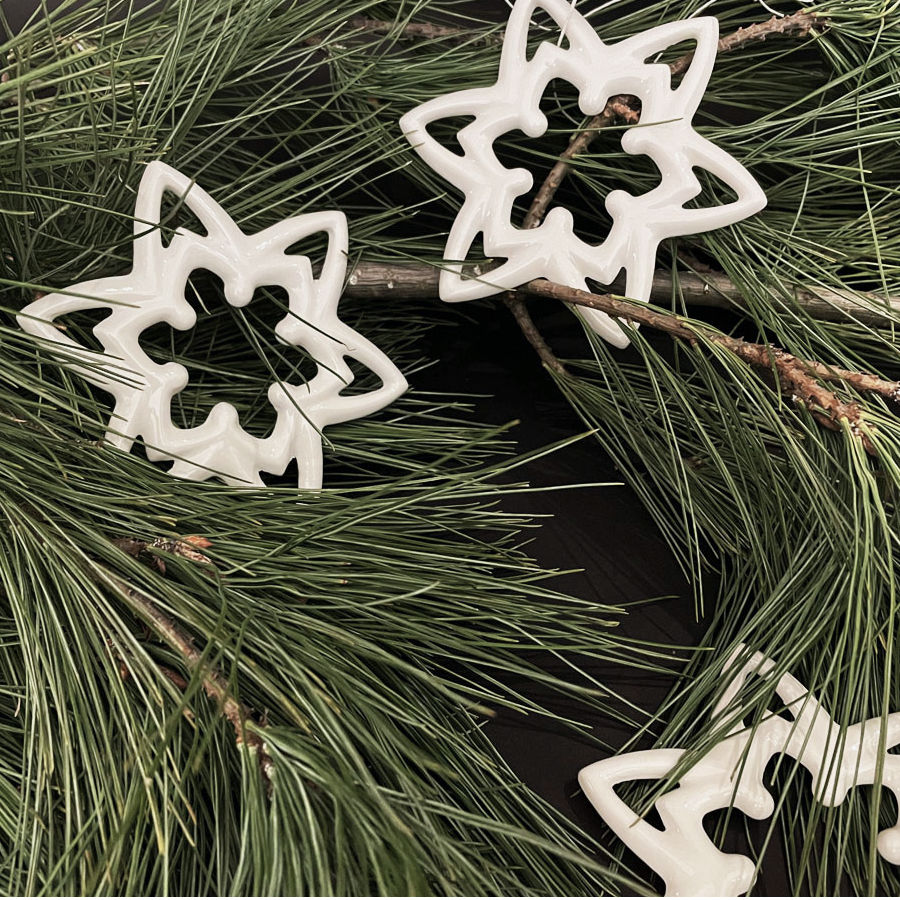 Porzellan-Schneekristalle als Weihnachtsanhänger, handgefertigt in Berlin. Feinesweißes Porzellandesign von Katy Jung – zeitloser Weihnachtsschmuck aus Porzellan.