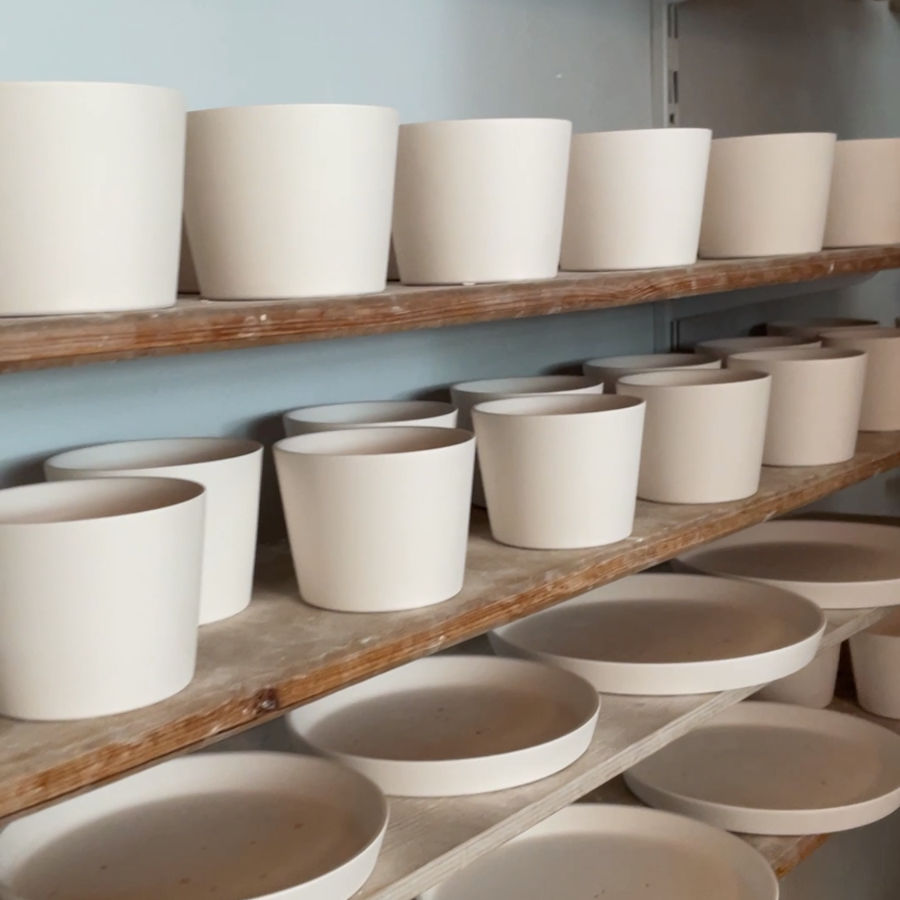 Becher und Teller frisch gegossen zum Trocknen im Regal bei feines weißes Berlin