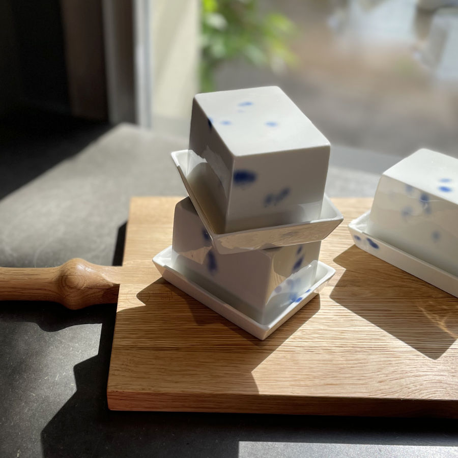 Kleine Butterdose aus Porzellan weiß mit kobaldblauen tupfen auf einem Holzbrett