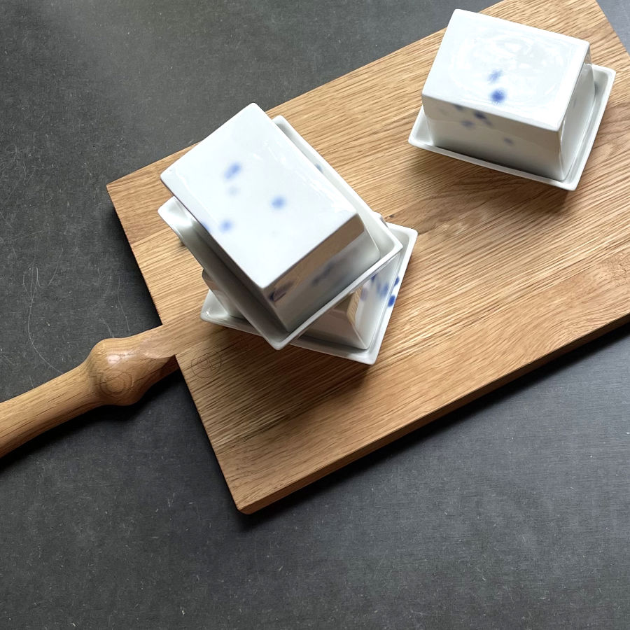 Kleine Butterdose aus Porzellan mit kobald blauen Tupfen auf Holzbrett