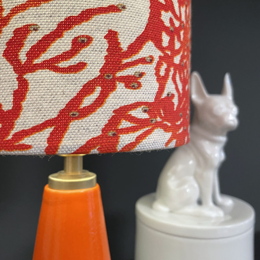 Detailansicht des französischen Halb-Panama-Leinenstoffs in Koralle Orange – Lampenschirm der feinesweißes Tischleuchte.