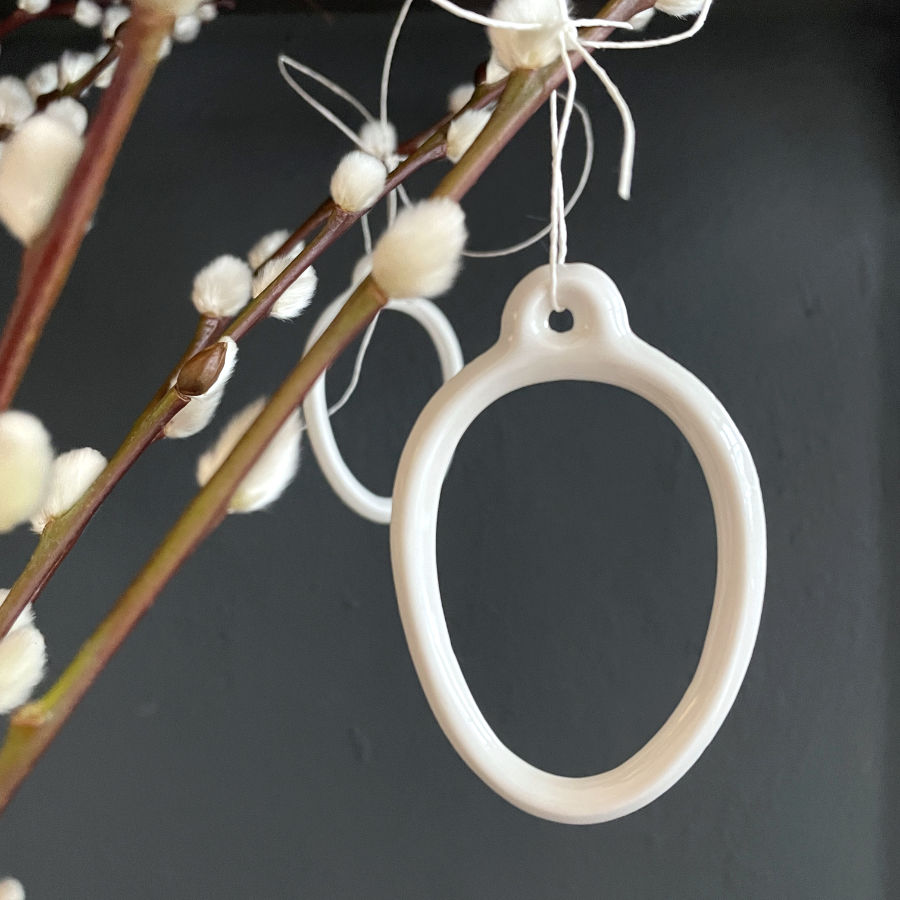 Ein Osteranhänger aus Porzellan von feines weißes Berlin in Ei Form.