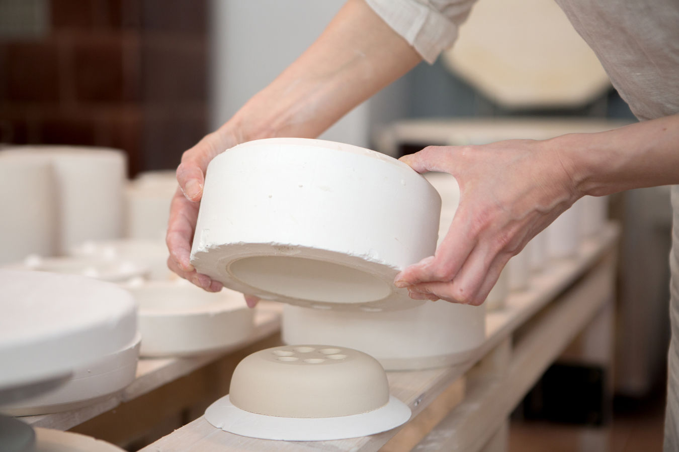 Hände beim ausformen einer gegossenen Seifenschale