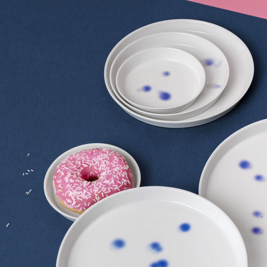 Teller aus Porzellan in vier Größen mit blauen tupfen. Dekor handgefertigt in Berlin und feines weißes, arrangiert mit Donut