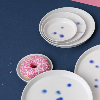 Teller aus Porzellan in vier Größen mit blauen tupfen. Dekor handgefertigt in Berlin und feines weißes, arrangiert mit Donut